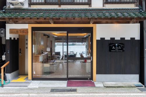 an entrance to a building with a sign on the door at 伊根舟屋の宿あうら-FUNAYA Aura- in Ine