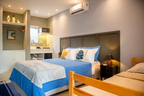 a bedroom with two beds and a kitchen at Studio Brisa da Ferradura - Búzios in Búzios