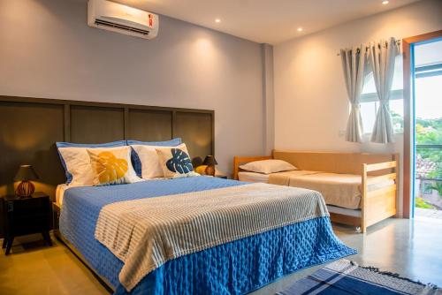 a bedroom with a large bed and a couch at Studio Brisa da Ferradura - Búzios in Búzios