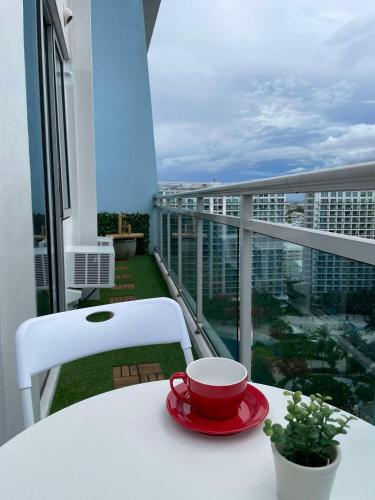 a red cup and saucer on a table on a balcony at Supreme Luxury 2BR Condo - Azure Urban Resort Residences near Manila Airport in Manila