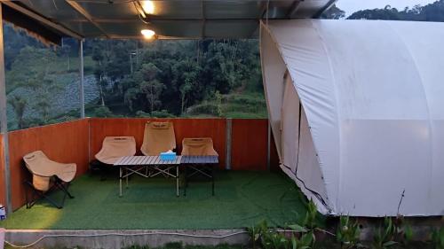 a tent with three chairs and a table in it at Mahkota Sangkuriang Bandung in Bandung