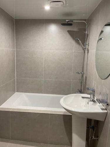 a bathroom with a bath tub and a sink at Londonker in Busan