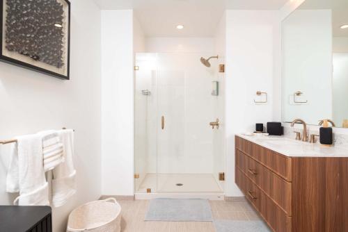 a white bathroom with a shower and a sink at Back-Bay Upscale Central Condo Rooftop & Parking in Boston