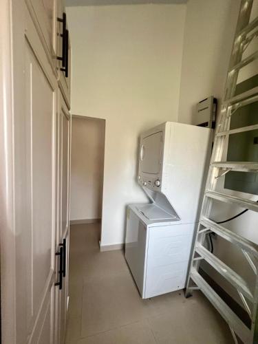 a small kitchen with a refrigerator and a shelf at La Casita 4BR Private Paradise with Pool in La Garita