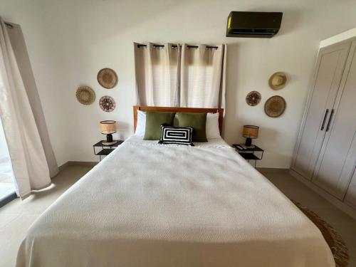 a bedroom with a large white bed with two lamps at La Casita 4BR Private Paradise with Pool in La Garita
