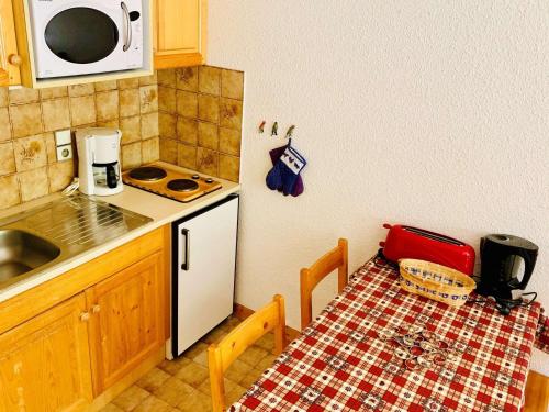 une cuisine avec une table et un réfrigérateur blanc dans l'établissement Appartement 2 pièces à Val d'Isère, proche centre et pistes, 4 pers, casier à skis - FR-1-411-299, à Val dʼIsère