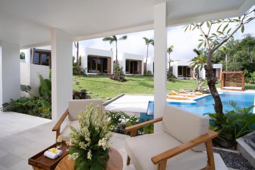 an outdoor patio with a table and chairs and a pool at Asri Village Two in Uluwatu