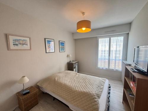 une chambre avec un lit et une télévision à écran plat dans l'établissement Appartement 2 pièces accès direct plage, parking privé - FR-1-197-604, à Les Sables-dʼOlonne