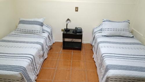 two beds sitting next to each other in a room at Hotel las Dunas in Iquique