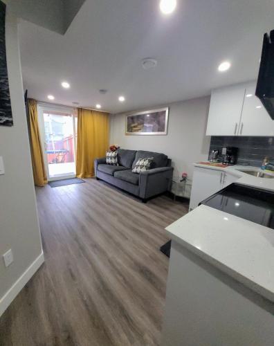 a living room with a couch and a kitchen at Spacious Basement Suite NW Calgary- 1bedroom 2 guest maximum in Calgary