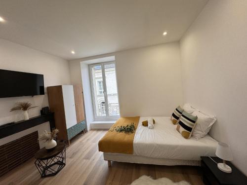 une chambre avec un lit et une grande fenêtre dans l'établissement Cozy Urban Nest Near Le Mans, à Écommoy