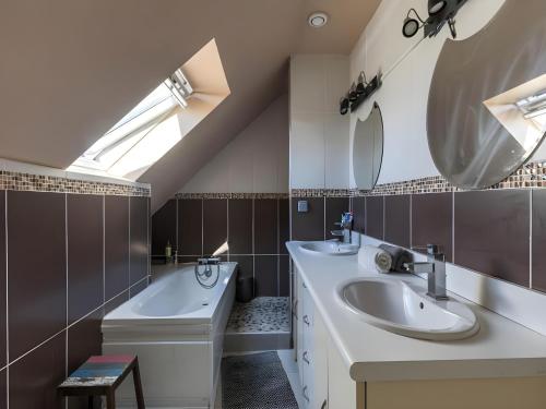 une salle de bain avec deux lavabos, une baignoire et un miroir dans l'établissement Trackside Retreat Ideal Base in Le Mans, au Mans