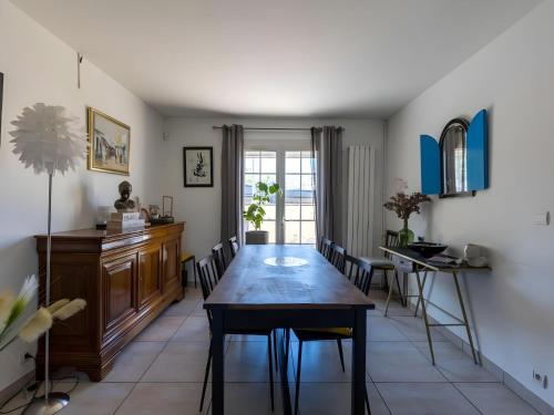 une salle à manger avec une table et des chaises en bois dans l'établissement Trackside Retreat Ideal Base in Le Mans, au Mans