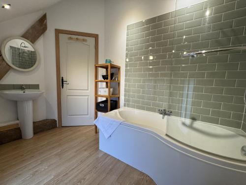 a bathroom with a bath tub and a sink at Barn in Aubigné-Racan with Heated Pool in Aubigné-Racan