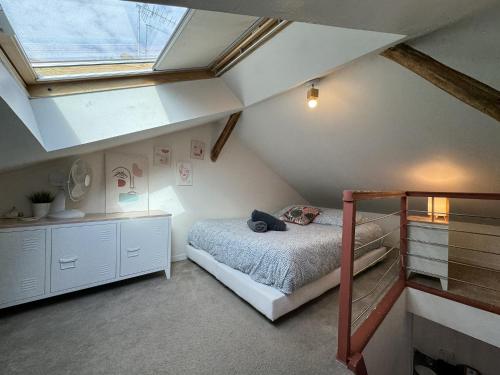 - une chambre mansardée avec des lits superposés et une fenêtre dans l'établissement Duplex in Le Mans near Place d'Alger, au Mans
