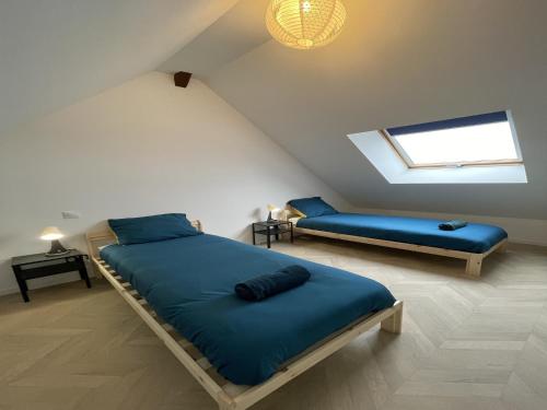 a attic bedroom with two beds and a window at Duplex in Noyen-sur-Sarthe near Le Mans in Noyen-sur-Sarthe