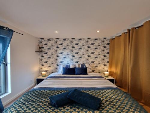 une chambre avec un grand lit avec des oreillers bleus dans l'établissement Apartment in Le Mans near City Center, au Mans