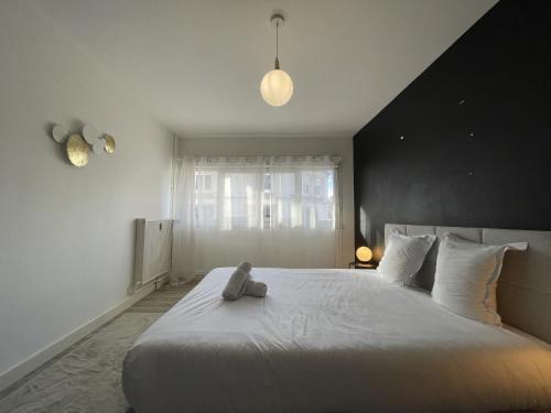 - un ours en peluche assis sur un lit dans une chambre dans l'établissement Apartment in Le Mans near Train Station, au Mans