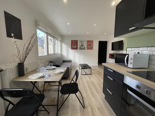 une cuisine avec une table et des chaises et un micro-ondes dans l'établissement Apartment in Le Mans near Train Station, au Mans