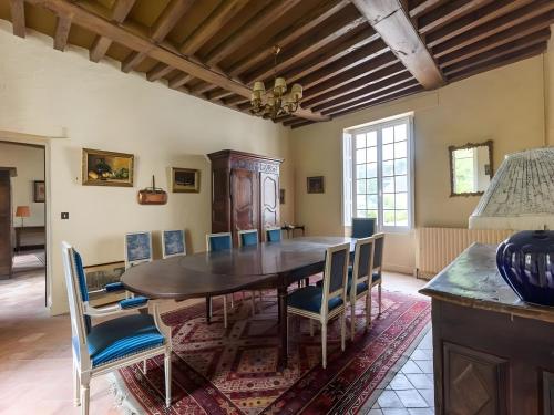 a dining room with a wooden table and chairs at Château in Touraine with Private Park in Le Lude