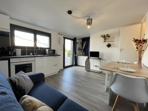 un salon avec un canapé bleu et une table dans l'établissement Apartment in Le Mans with Private Parking, au Mans