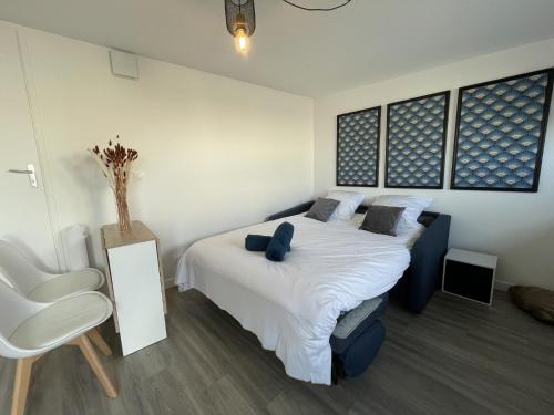 - une chambre avec un grand lit blanc et une chaise dans l'établissement Apartment in Le Mans with Private Parking, au Mans