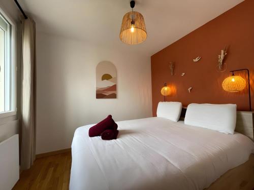 un ours en peluche rouge assis sur un lit blanc dans l'établissement Apartment in Le Mans near 24 Hours Circuit, au Mans