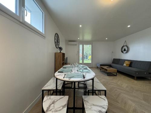 un salon avec une table et un canapé dans l'établissement House in Le Mans with Private Garden, au Mans