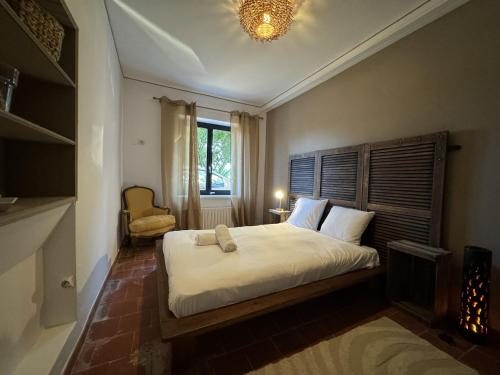 une chambre avec un grand lit blanc avec une fenêtre dans l'établissement House in Mansigné with Fenced Garden, à Mansigné