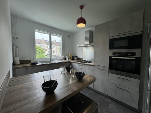 - une cuisine avec une table en bois et des bols dans l'établissement Holiday Home in Le Mans near 24H Circuit, au Mans