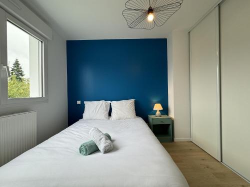 - une chambre avec un grand lit blanc et un mur bleu dans l'établissement Holiday Home in Le Mans near 24H Circuit, au Mans