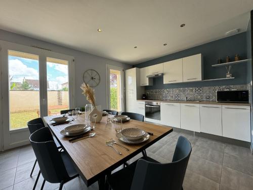 une cuisine et une salle à manger avec une table et des chaises en bois dans l'établissement House in Arnage near Le Mans Circuit, à Arnage