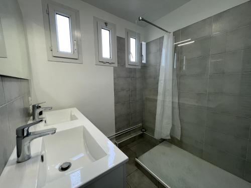 une salle de bain blanche avec un lavabo et une douche dans l'établissement Apartment in Le Mans near 24 Hours Circuit, au Mans