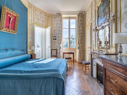 - une chambre avec un lit bleu et une table dans l'établissement Château in Sarthe with Heated Pool, à Dangeul