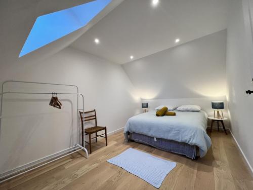 une chambre avec un lit et une lucarne dans l'établissement House in Ballon near Le Mans Circuit, à Ballon