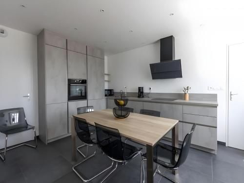 Il comprend une cuisine avec une table et des chaises en bois. dans l'établissement Farmhouse in Laigné near Le Mans Circuit, à Laigné-en-Belin