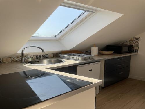 une cuisine mansardée avec un évier et une fenêtre dans l'établissement Studio in Le Mans near 24 Hours Circuit, au Mans
