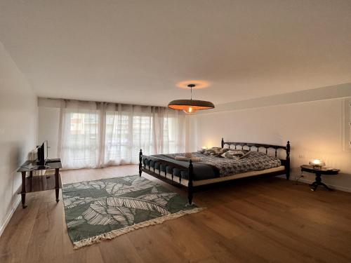 une chambre avec un lit et une grande fenêtre dans l'établissement Apartment in Le Mans with Retro-Chic Style, au Mans