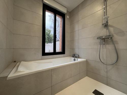 une salle de bain avec une baignoire et une fenêtre dans l'établissement Apartment in Écommoy near Le Mans Circuit, à Écommoy