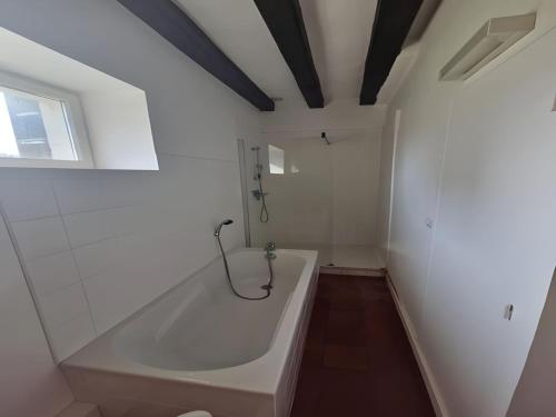 La salle de bains est pourvue d'une baignoire blanche et d'une fenêtre. dans l'établissement Stone House in La Flèche with Garden & BBQ, à Thorée-les-Pins