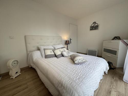 Cette chambre comprend un lit blanc avec des oreillers et une commode. dans l'établissement House in Ruaudin near Le Mans Circuit, à Ruaudin