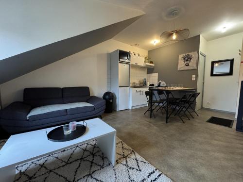 un salon avec un canapé et une table dans l'établissement Apartment near Le Mans 24H Circuit, à Yvré-lʼÉvêque