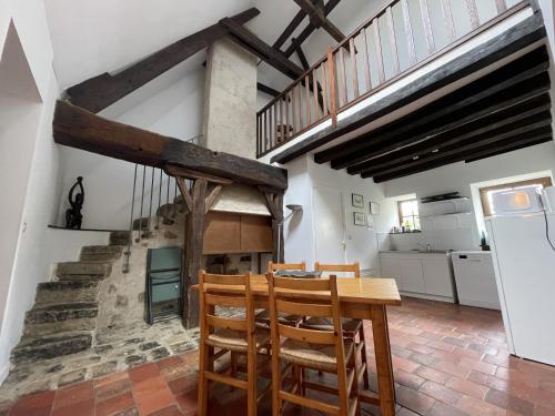 une cuisine et une salle à manger avec une table et des chaises en bois dans l'établissement Stone House in Sarthe with Historic Chapel, à Thorée-les-Pins