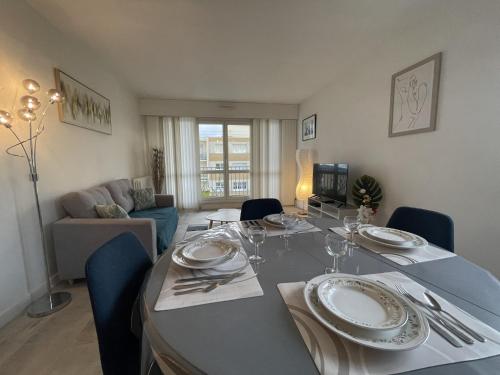 une salle à manger avec une table avec des assiettes et des verres à vin dans l'établissement Apartment in Le Mans near 24 Hours Circuit, au Mans