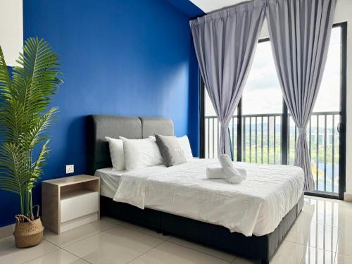 a blue bedroom with a bed and a large window at Alinea Suites by Moka in Shah Alam