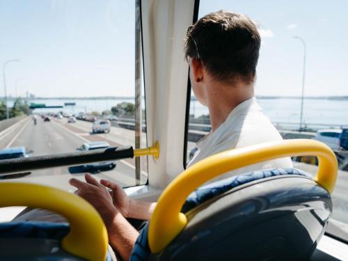 a man sitting on a bus looking out the window at Attic Backpackers in Auckland