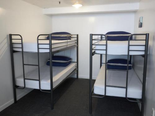 two bunk beds in a room with blue towels at Attic Backpackers in Auckland
