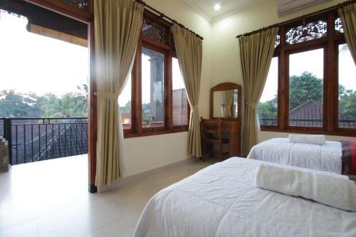 sypialnia z 2 łóżkami i dużymi oknami w obiekcie Taman Ayu Ubud w mieście Ubud