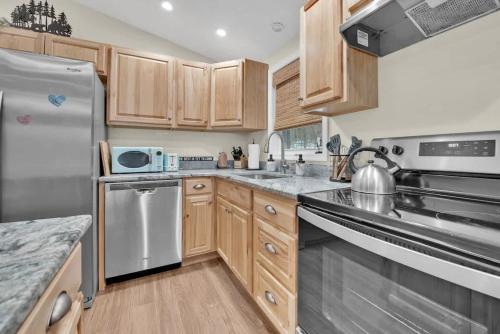 a kitchen with wooden cabinets and stainless steel appliances at A Refined Retreat in Lackawaxen
