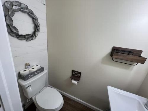 a bathroom with a toilet and a wreath on the wall at A Refined Retreat in Lackawaxen